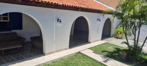 a courtyard of a house with three arches at Casarão Hostel Peró in Cabo Frio
