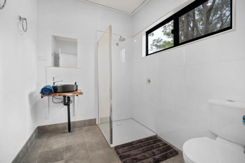 uma casa de banho com um chuveiro, um WC e um lavatório. em Litchfield Tropical Stay em Batchelor