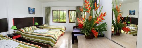 a room with two beds and flowers in it at Hotel Puerto Ballesta in Tonsupa