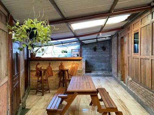 un patio con mesas y sillas de madera y un bar en StayBareng di Kasongan en Jarakan