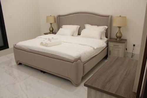 a bedroom with a large white bed with two lamps at فيلا عصرية بمدخل خاص و مسبح in Riyadh