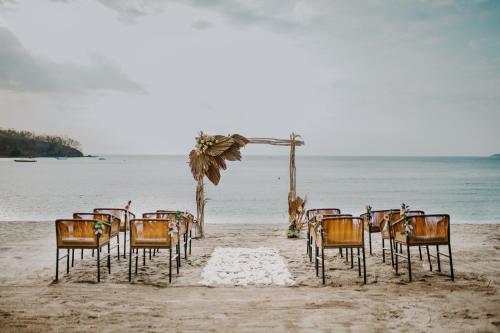 a group of chairs sitting on the beach at The Kayana Beach Lombok in Senggigi 