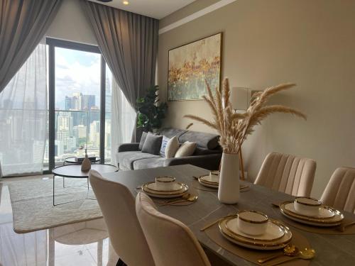 a living room with a table with chairs and a couch at Lucentia Residence BBCC Lalaport at Kuala Lumpur By Luxe Home in Kuala Lumpur