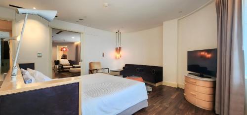 a hotel room with a bed and a television at Ascott Raffles Place Singapore in Singapore