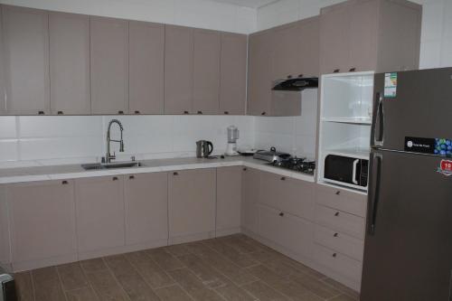 a kitchen with white cabinets and a stainless steel refrigerator at فيلا عصرية بمدخل خاص و مسبح in Riyadh