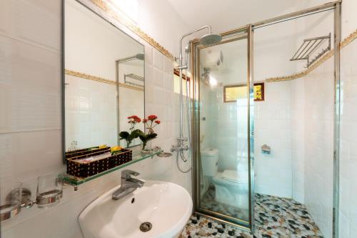 W łazience znajduje się umywalka i przeszklony prysznic. w obiekcie Tam Coc Sunshine Resort w mieście Ninh Binh
