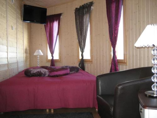 a bedroom with a bed and a couch and windows at Villa Muu, LaatuLomat in Juva