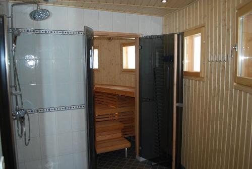 ein Bad mit einer Dusche und einer ebenerdigen Dusche in der Unterkunft Villa Muu, LaatuLomat in Juva
