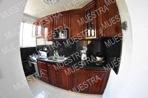 a bathroom with wooden cabinets and a sink in it at Apartamento en la carreras próximo al monumento in Santiago de los Caballeros