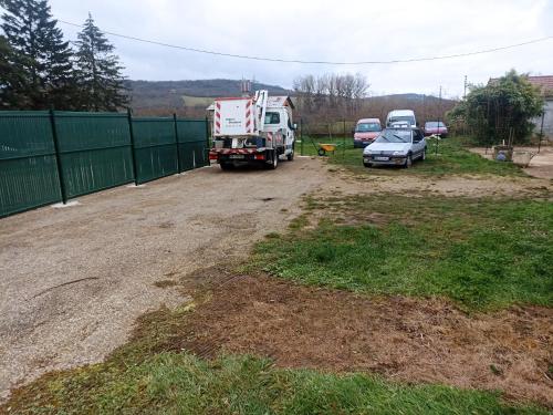 two trucks and a car parked next to a fence at maisonnette dans propriété 