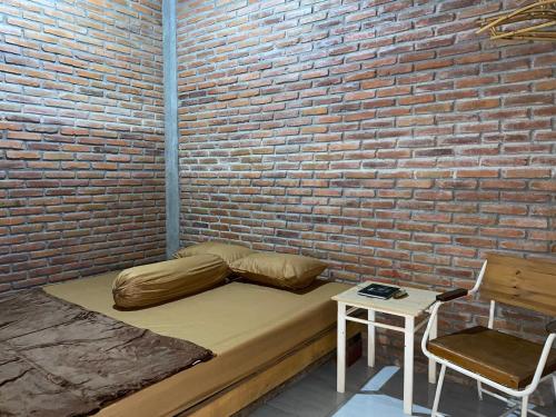 Habitación con cama y pared de ladrillo en StayBareng di Kasongan en Jarakan