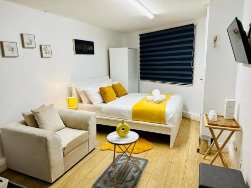 a bedroom with a bed and a couch and a table at Premium Studio Flat 04 in Central London in London