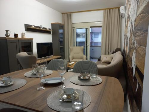a living room with a wooden table with glasses on it at Ulcinj Apartments in Ulcinj
