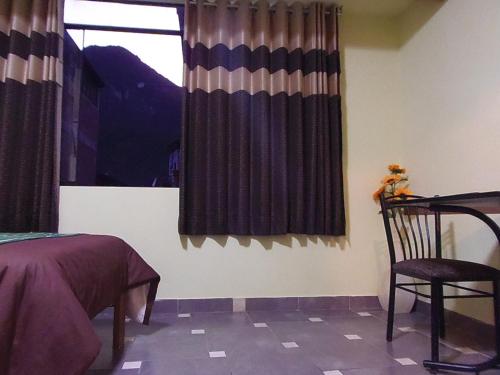 a bedroom with a window with curtains and a chair at Hostal Pablo's House in Machu Picchu