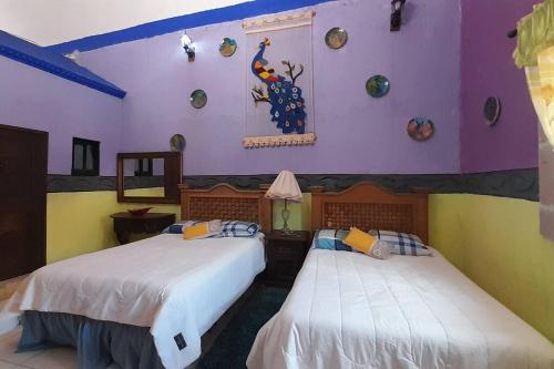HuichapanにあるHacienda Los Girasoles Siglo XVIIIの紫の壁のドミトリールーム ベッド2台