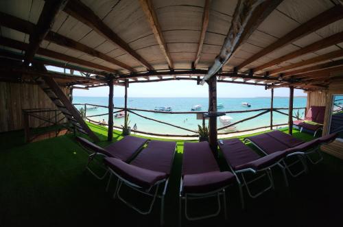 a group of chairs with the ocean in the background at Ecohotelhector in Playa Blanca