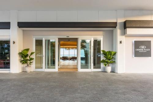 an entrance to a building with two potted plants at Crowne Plaza Resort Guam in Tumon