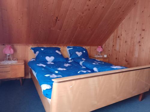 a bed in a room with a wooden ceiling at Dom leśny w Konarzynach in Stara Kiszewa