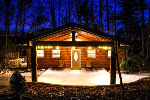a log cabin with lights on it at night at The Escape Cabin in Boone