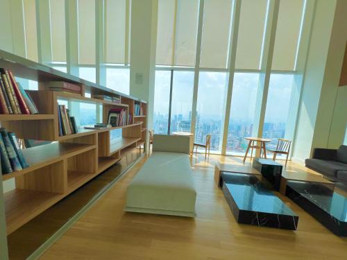 uma sala de estar com muitas janelas altas em The Platinum KLCC By Sky Pool em Kuala Lumpur