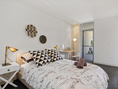 a bedroom with a large bed and a desk at 2bdrm Skyline Views - Prime for River, WACA, OPTUS Stadium in Perth
