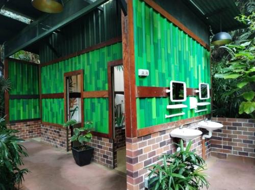 a green bathroom with two urinals on a brick wall at Lagoon Villa at Sunway Lagoon Theme Park in Petaling Jaya