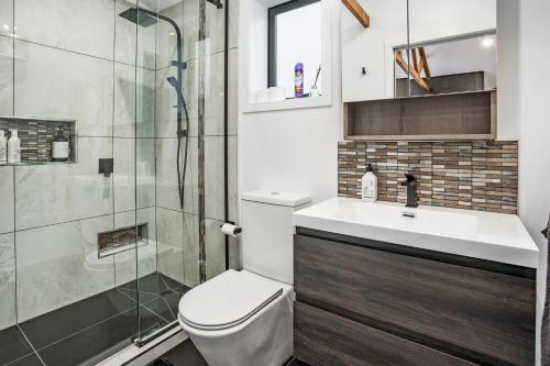 a bathroom with a toilet and a glass shower at Studio Unit with Spa Bath in Christchurch