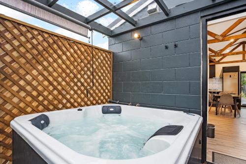 a large bath tub in a room with a patio at Studio Unit with Spa Bath in Christchurch