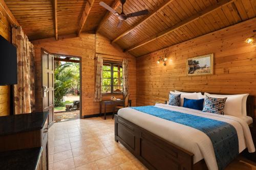 um quarto com uma cama grande num quarto de madeira em Fortune Resort Benaulim, Goa - Member ITC's Hotel Group em Benaulim