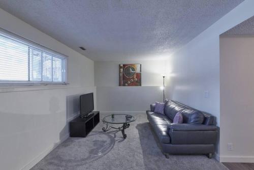 a living room with a leather couch and a table at 2bedroom suite w/ great access into & out the city - 7818 in Calgary