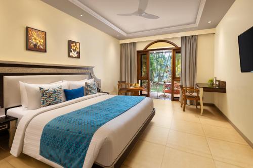a bedroom with a large bed with a blue blanket at Fortune Resort Benaulim Goa - Member ITC Hotels' Group in Benaulim