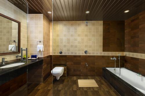 W łazience znajduje się toaleta, wanna i umywalka. w obiekcie Fortune Resort Benaulim, Goa - Member ITC's Hotel Group w mieście Benaulim