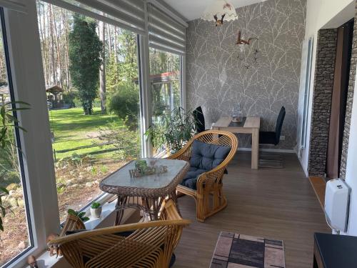 eine Veranda mit einem Tisch, Stühlen und einem Tisch in der Unterkunft NEUES Ferienhaus "Kolibri" direkt in Wandlitz, in Wandlitz