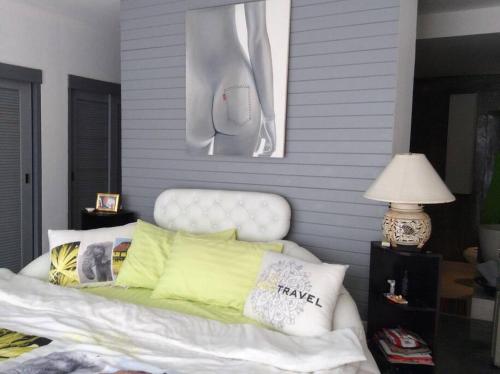 a bedroom with a white bed with pillows on it at La maison du bonheur à samui in Koh Samui