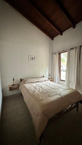 1 cama grande en un dormitorio con ventana en Travels en Las Flores