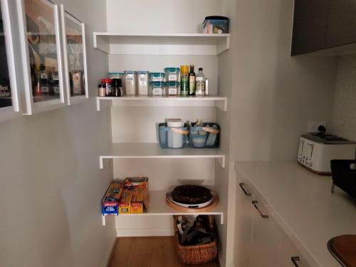 a kitchen with white shelves on the wall at NAUTILUS in Point Lonsdale