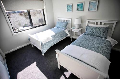 a bedroom with two beds and a window at NAUTILUS in Point Lonsdale