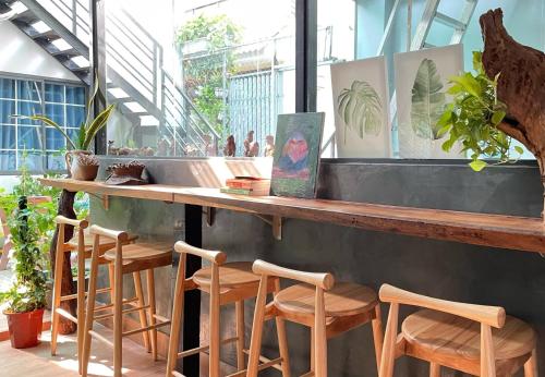 un bar con taburetes de madera en un restaurante en Vania House, en Ho Chi Minh