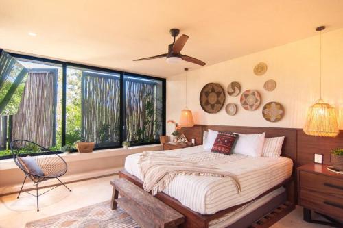 a bedroom with a bed and a fan and windows at Spectacular Villa Gaia/PH/private pool in Tulum