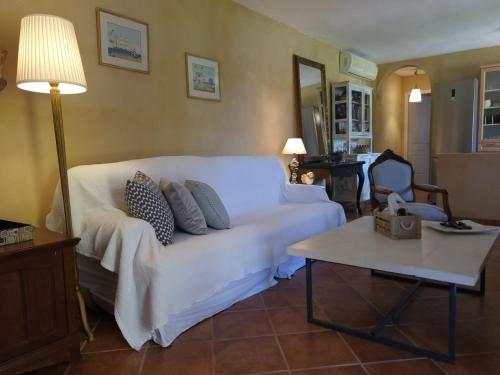 a living room with a white couch and a table at Villa Agali. in Agia Anna