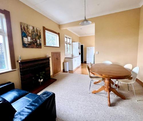 a living room with a wooden table and a dining room at NO PARTY ALLOWED, Peaceful, Spacious, central Petone, free unlimited Fibre Wi-Fi & free parking in Lower Hutt