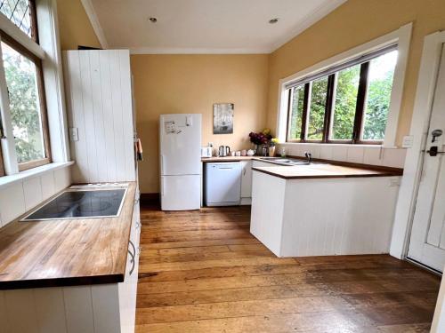 a kitchen with white cabinets and a white refrigerator at NO PARTY ALLOWED, Peaceful, Spacious, central Petone, free unlimited Fibre Wi-Fi & free parking in Lower Hutt