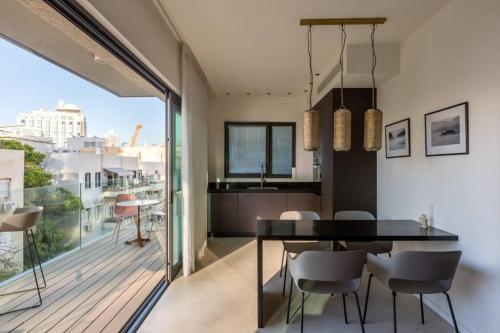 ein Esszimmer mit einem Tisch und einem Balkon in der Unterkunft BnBennaim - Bella apartment in Tel Aviv