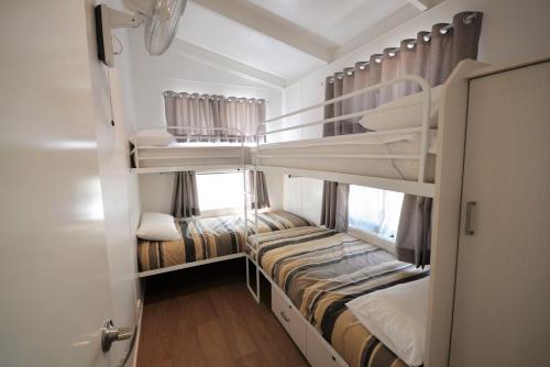 a room with two bunk beds and a window at Rivergardens Holiday Park Mildura in Gol Gol