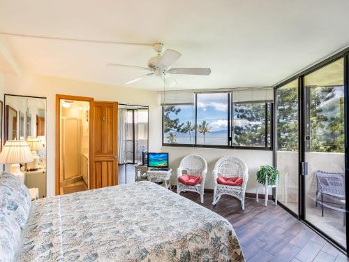 1 dormitorio con 1 cama, sillas y ventanas en Maui Sunset A-322, 3 Bedrooms, Ocean View, Pool, Tennis, Sleeps 8, en Kihei