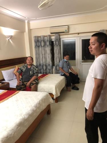 a group of men in a hotel room with beds at Khách sạn NHẬT MINH Cửa Lò in Cửa Lò