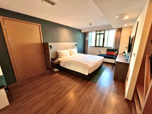 a bedroom with a bed and a sliding door at Holiday Inn Express Qingdao City Center by IHG in Qingdao