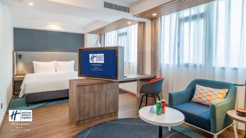 a hotel room with a bed and a tv at Holiday Inn Express Qingdao City Center by IHG in Qingdao