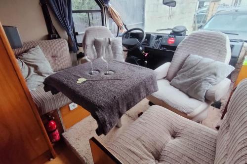 - un salon avec une table, des chaises et une camionnette dans l'établissement Camping-car vintage, à Venette