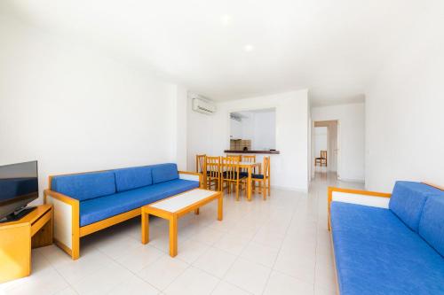 a living room with two blue couches and a table at Apartament Massanet ba in Canyamel
